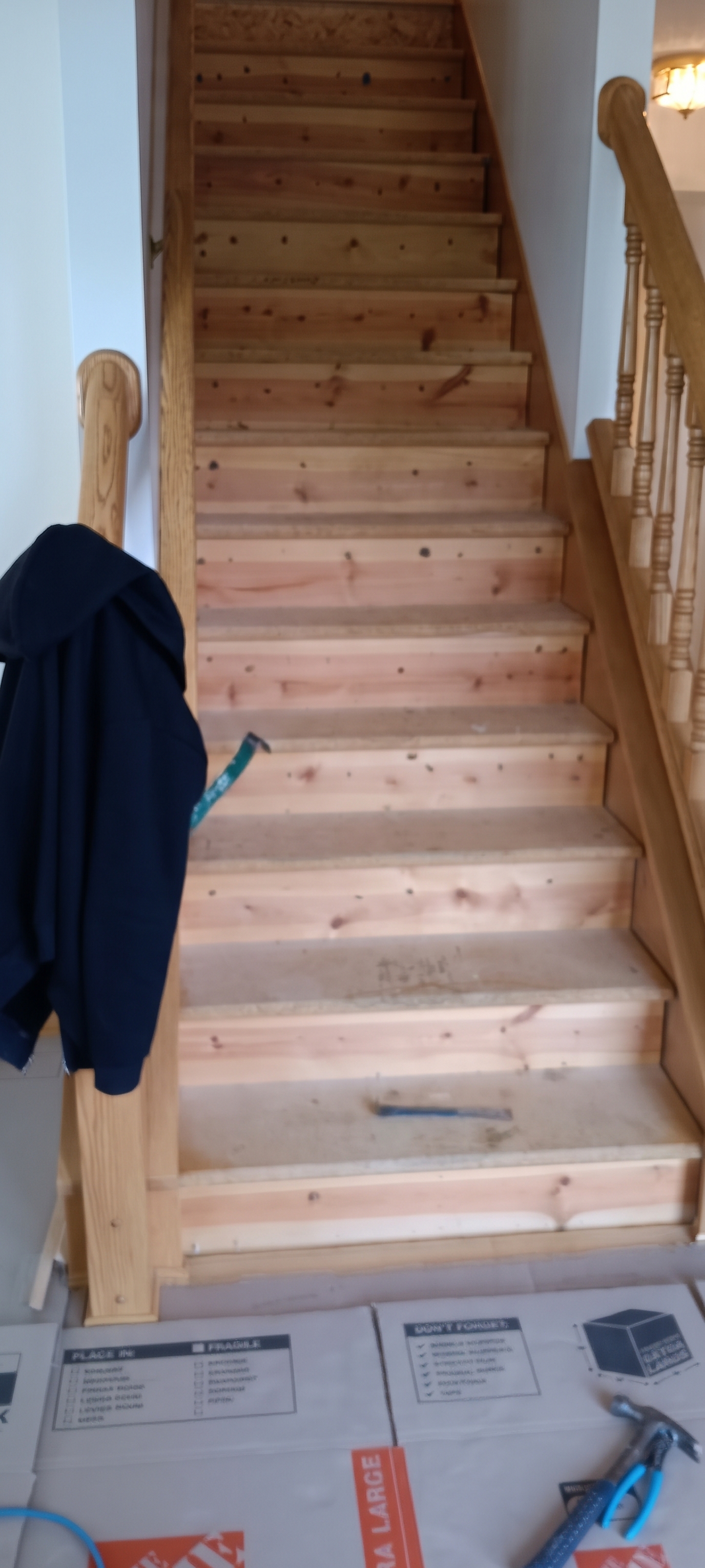 Staircase with the carpet and pad stripped away, exposing the original treads and risers underneath